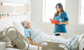 Young woman nurse chatting with her elderly woman patient
